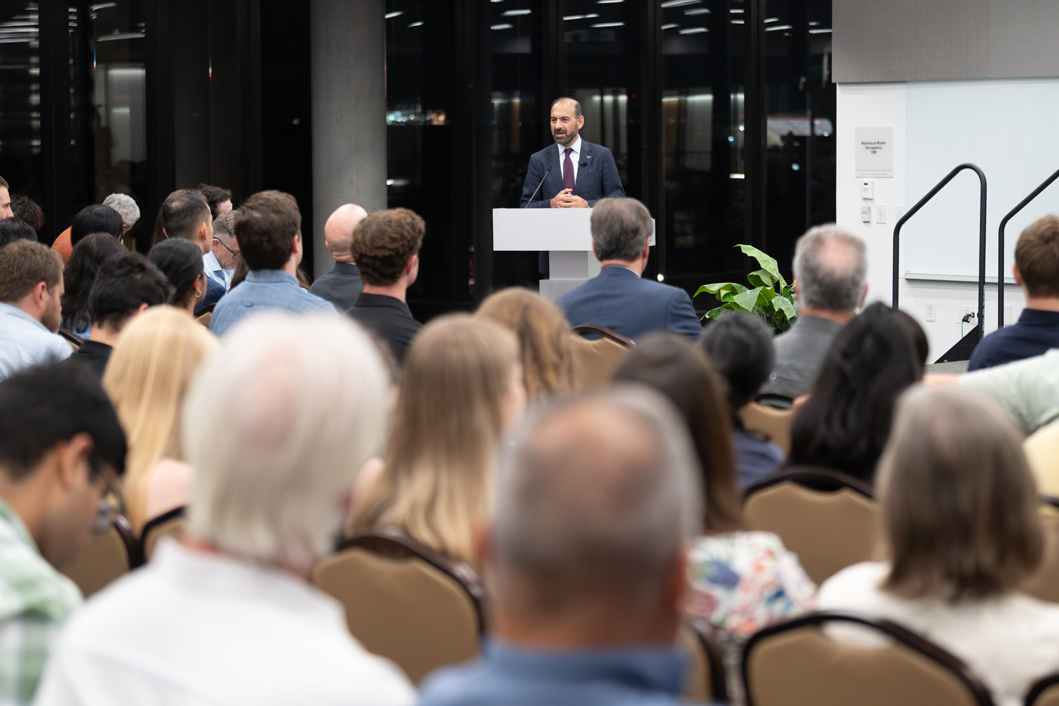 Dilawar Syed addressing an audience from a lectern
